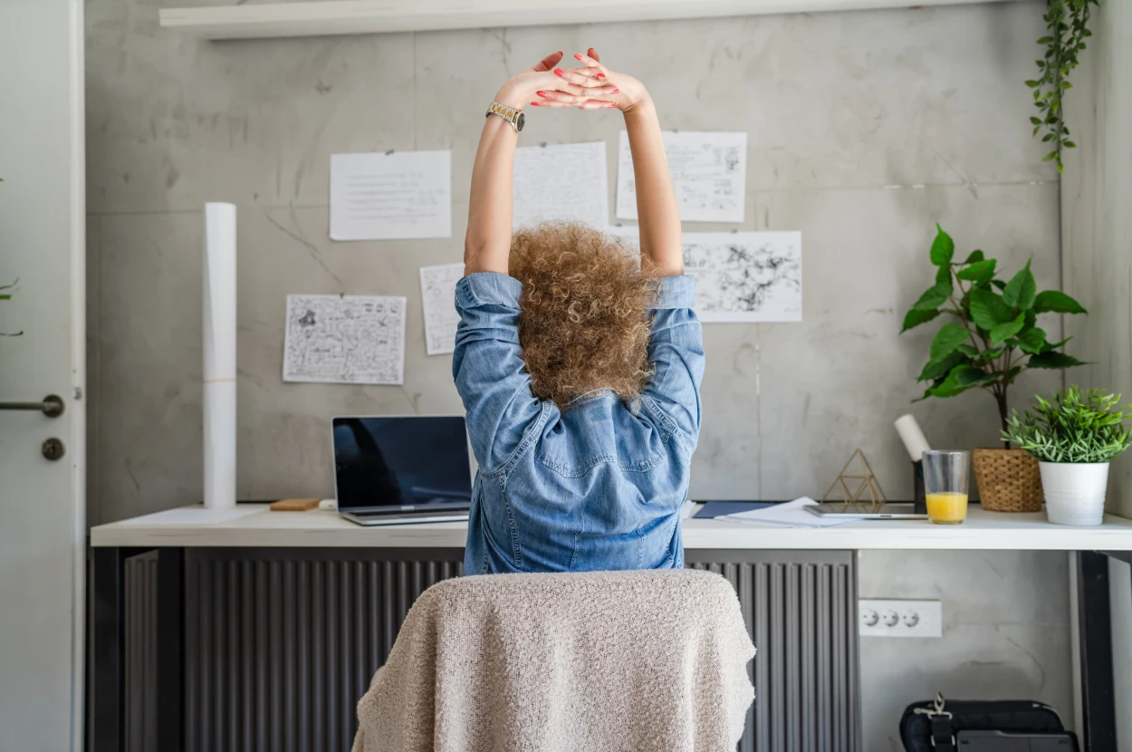 Office team members stretching at their workstations during a planned movement break